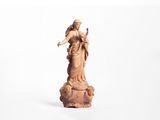une image représentant une statue d'une femme tenant un oiseau sur un rocher