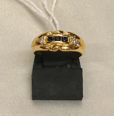 a close up of a gold ring with black and white stones on it