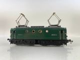 a green train on the tracks on a white surface