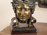 une statue représentant une femme à tête de chèvre posée sur une table