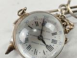 a small silver clock with roman numerals on it