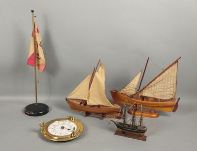 trois voiliers miniatures et une horloge posés sur une table