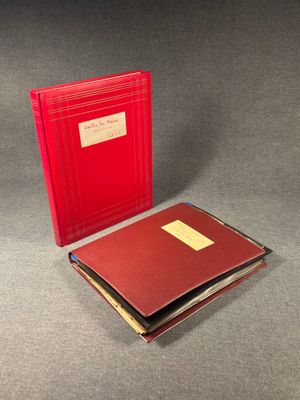 two red books sitting on top of a table next to each other