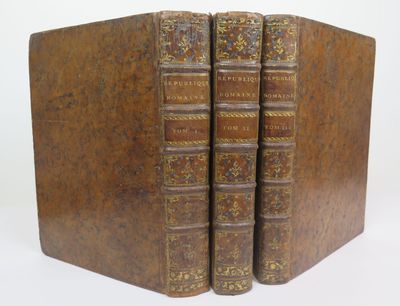two old books sitting on top of each other on a white surface