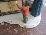 a figurine of a man standing in front of a tv