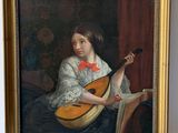 painting of a woman with a lute in a gold frame on a white wall