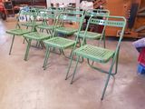 de nombreuses chaises vertes dans une pièce où il y a beaucoup d'objets par terre
