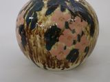 a small vase that is sitting on a white surface