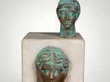 a close up of a sculpture of a head on a block