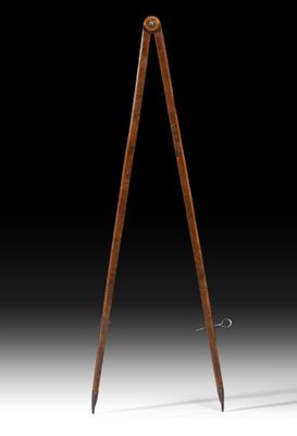 une lampe à trépied en bois surmontée d'un abat-jour noir