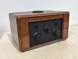 une vieille radio en bois posée sur une table blanche