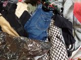 a pile of clothes that is sitting on a bed