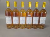six bottles of wine are lined up on a table
