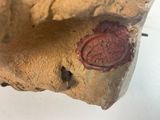 a wax seal on a piece of rock with a stick sticking out of it