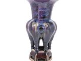 un vase violet posé sur un socle