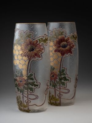 deux vases avec des fleurs peintes dessus, posés sur une table