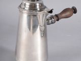 an antique silver coffee pot with a wooden handle on a white background