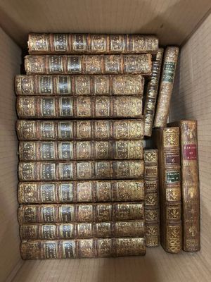 a box full of old books sitting on top of each other