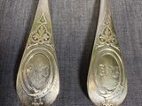 two silver spoons with a picture of a man and woman on them