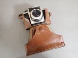 a brown leather camera case with a camera attached to it