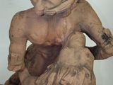 a statue of a child sitting on top of a tree stump