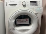 une machine à laver sur laquelle est accrochée une affiche