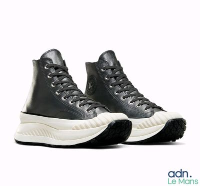 black leather high top sneakers with white soles on a white background