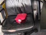 une chaise de bureau noire sur laquelle est posé un chapeau rouge