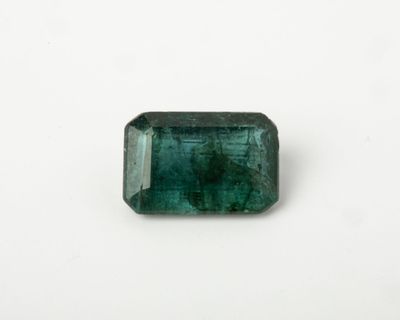 a green emerald stone on a white surface