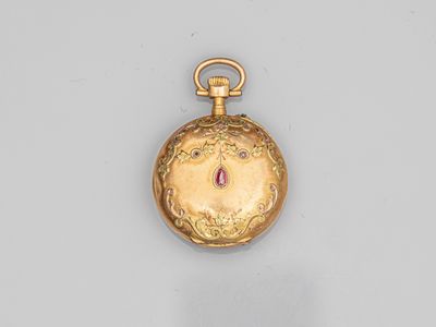 a close up of a gold pocket watch on a white surface