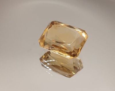 two yellow sapphires sitting on top of each other on a white surface
