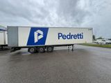 a white semi truck with a blue and white logo parked in a parking lot