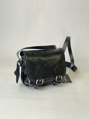 the small black leather bag is sitting on a white surface
