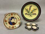 a plate with a picture of a man on it next to cups and saucers