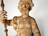 statue of a man holding a candle in his right hand and a candle in his left hand