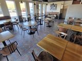 de nombreuses tables et chaises dans un restaurant doté de nombreuses fenêtres