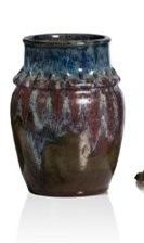 un vase marron et bleu à côté d'un chat marron et blanc