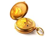 a gold pocket watch that has a gold face on it