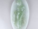 une photo d'une sculpture en jade vert représentant une femme et un enfant