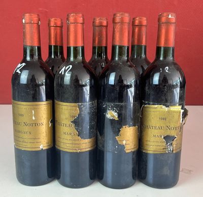 six bouteilles de vin rouge sont alignées sur un comptoir