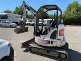 a small excavator that is parked in a parking lot