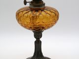 une lampe à huile à l'ancienne posée sur une surface blanche, avec un fond blanc