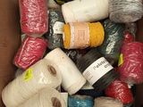 many spools of yarn in a box together