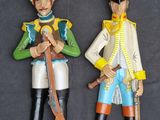 two figurines of soldiers that are standing next to each other