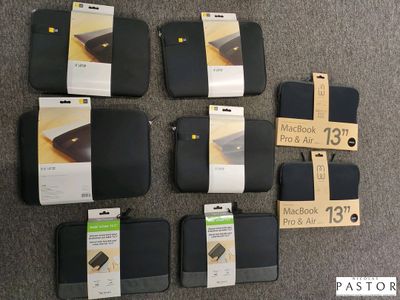 Six housses d'ordinateur portable noires sont posées sur un tapis, avec une étiquette de prix