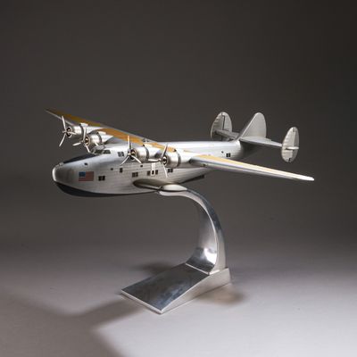 une maquette d'avion en argent posée sur un socle métallique