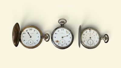 trois types différents de montres de poche sont présentés sur une surface blanche