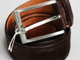 ceinture en cuir marron avec une boucle argentée sur un fond blanc