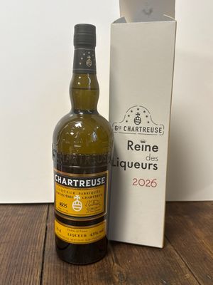 une photo montrant une bouteille de vin posée à côté d'une boîte sur une table