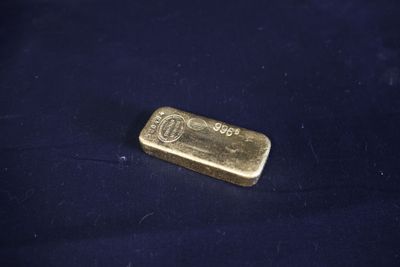 un lingot d'or posé sur un tissu bleu
